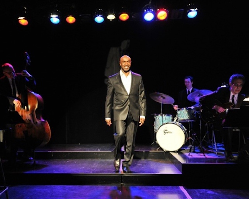 Photograph of Don Stewart, Canadian musician, performing on stage. His faith and love are expressed through music, drawing thunderous applause.